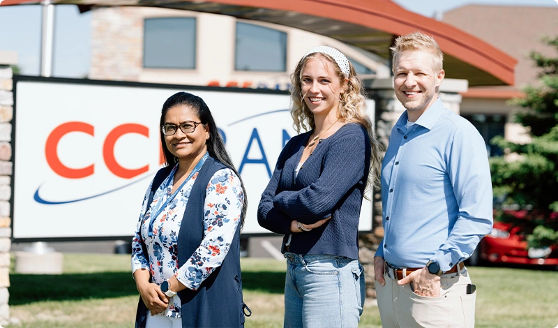 Team Members Standing by Company Signage