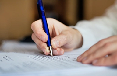 Signing a Document with a Blue Pen