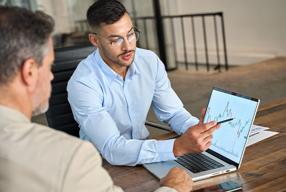 An Older White Man Reviewing Data on a Laptop with Advisor